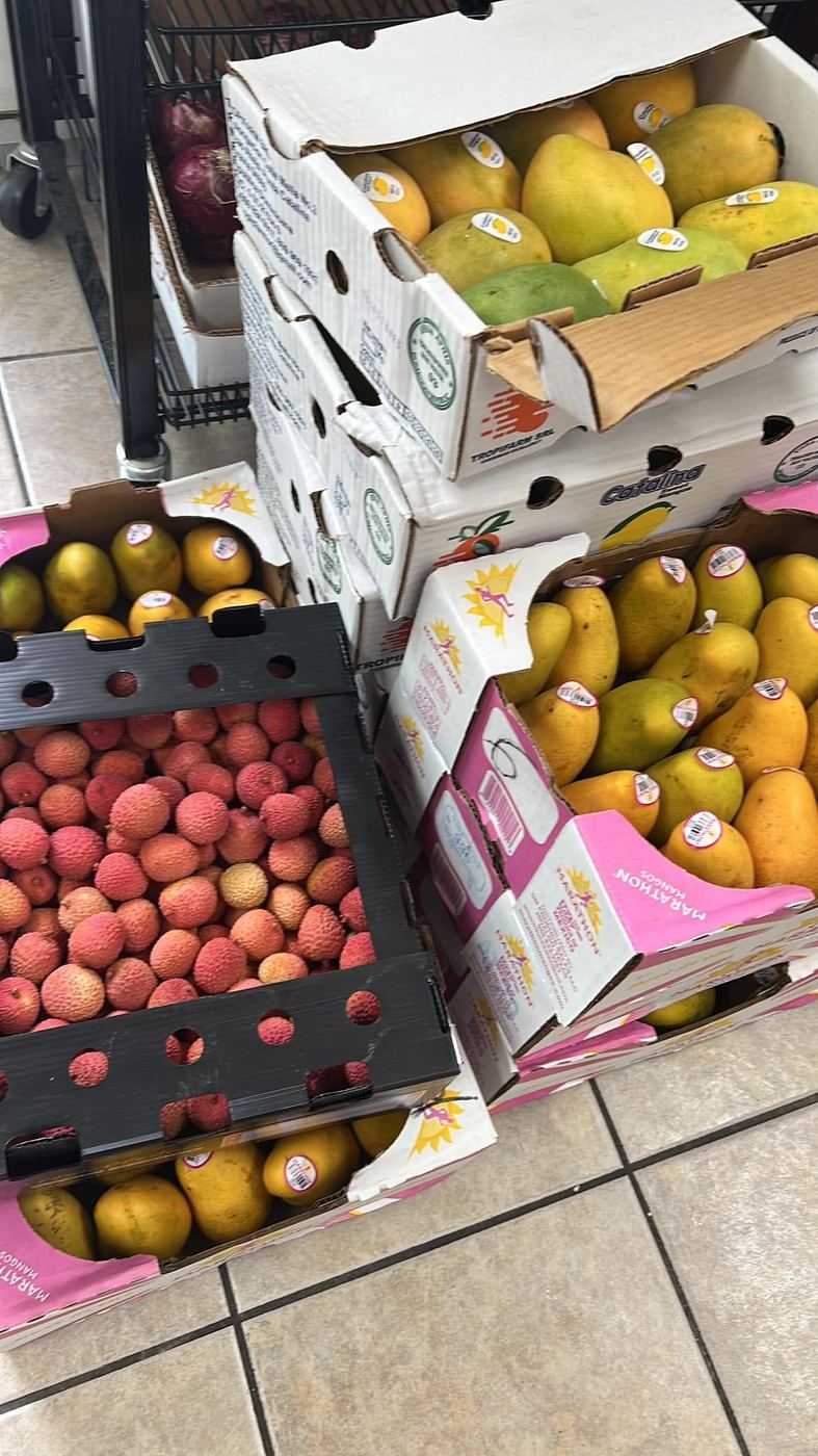 Boxes of ripe mangoes and fresh lychees
